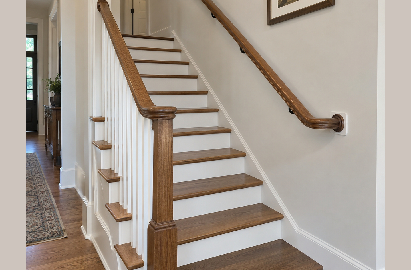 Indoor staircase illustrating handrail vs guardrail: a wall-mounted graspable handrail alongside traditional white balusters forming an open-side guard