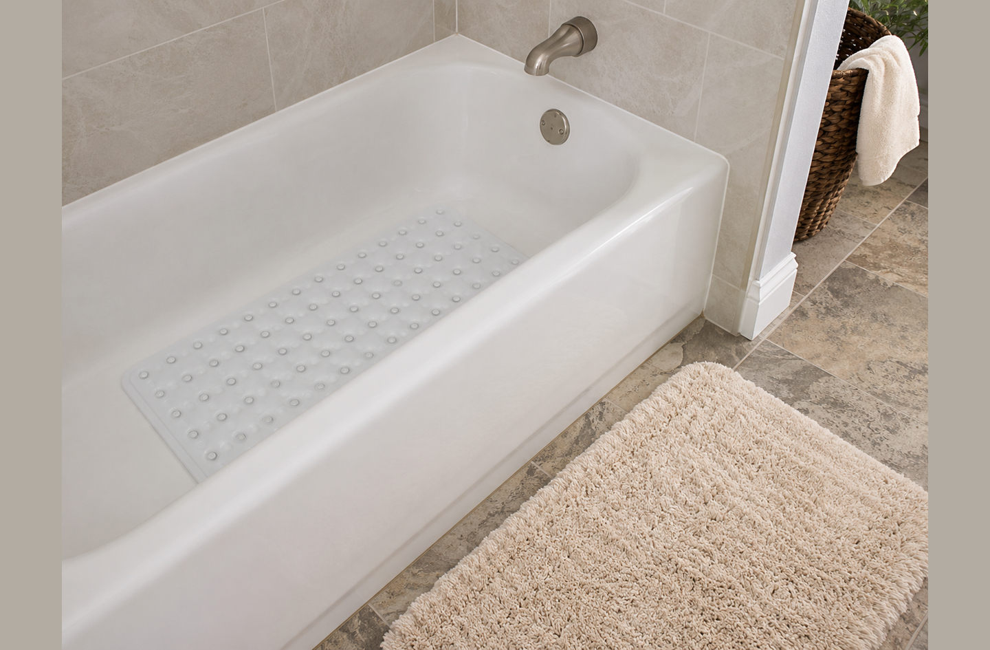 A white rectangular slip-resistant mat positioned inside a porcelain bathtub, showing in-tub suction cup mat placement