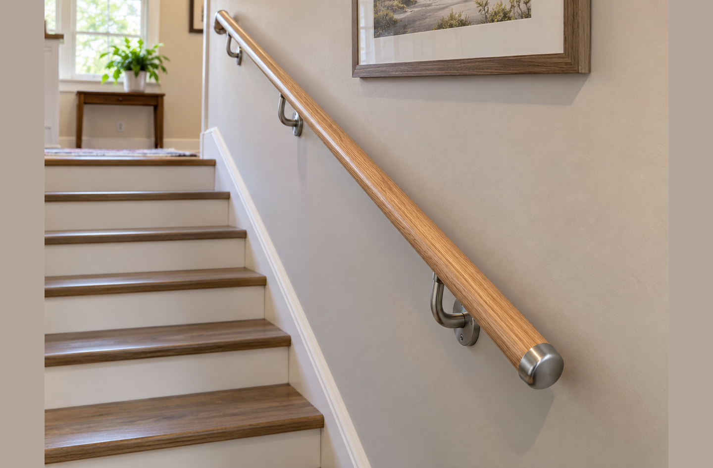 A natural wood stair handrail with brushed metal brackets on a light wall, the kind of installation a homeowner should assess before deciding to replace stair handrail hardware.